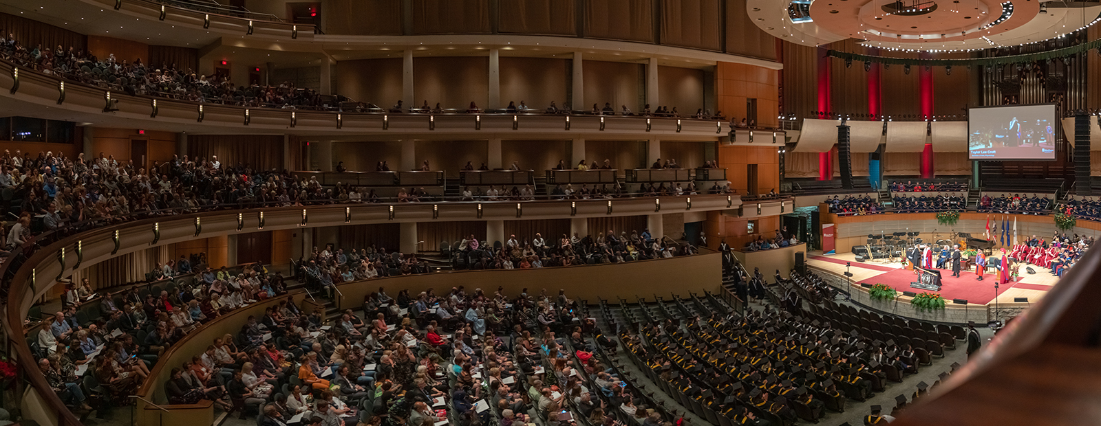 grads in black gowns at ceremony