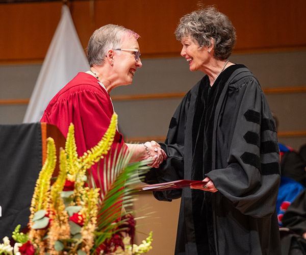 honorary doctorate recipient shaking hands with presenter of award