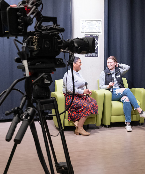 two female students with camera