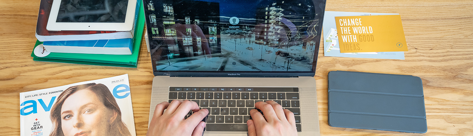 student at laptop with magazine beside him