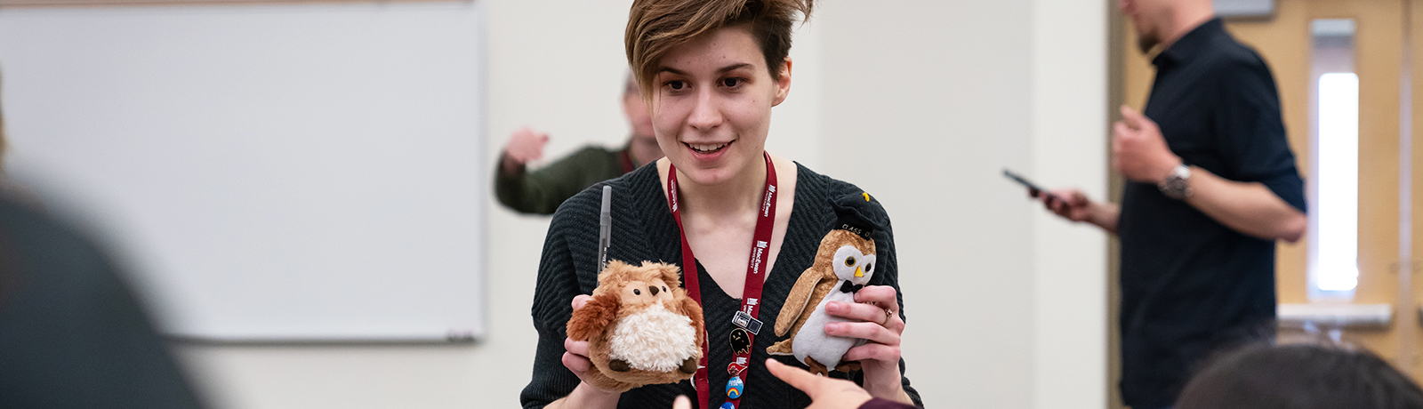 student holding stuffed animals