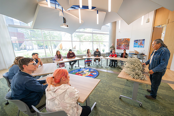 knowledge keeper speaking to classroom with sage in front of him