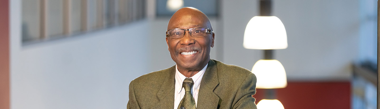 William (Bill) Agamah stands on the stairs in the Robbins Health Learning Centre