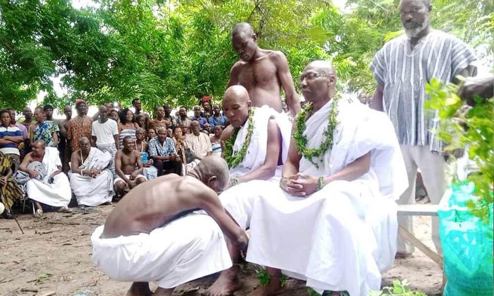 Bill Agamah sits dressed in white robes during the installation ceremony