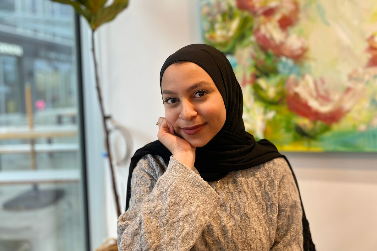 Fattima Deiab rests her chin in her hand and smiles at the camera