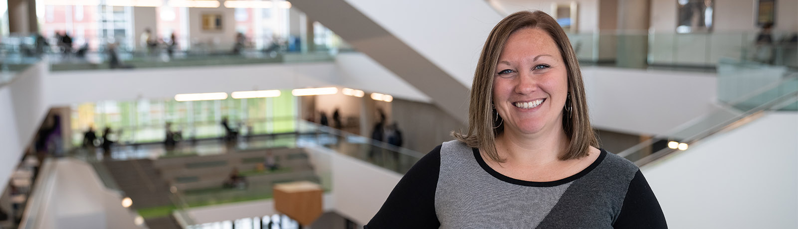 Dr. Natalia Rohatyn-Martin stands, smiling, in the Allard Hall atrium