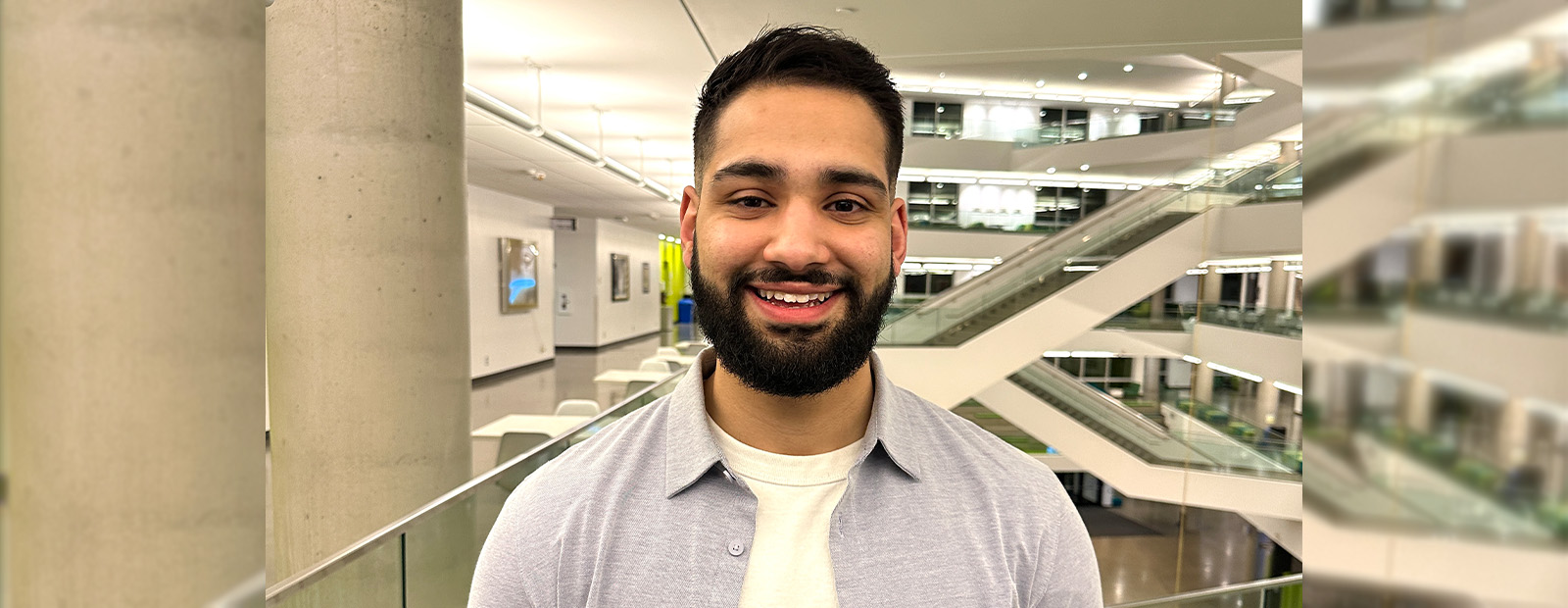 Harnoor Dhaliwal stands in front of the staircases in Allard Hall