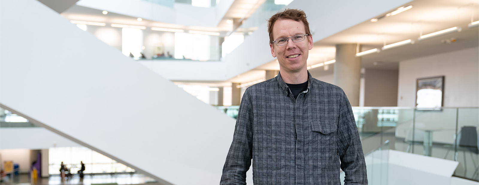 Dr. Kevin Judge stands in front of the staircase in Allard Hall.