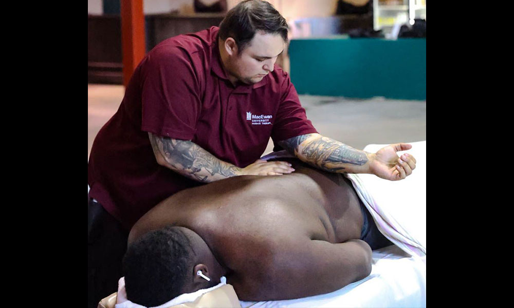 A massage therapy student works on the back of an Elks training camp player