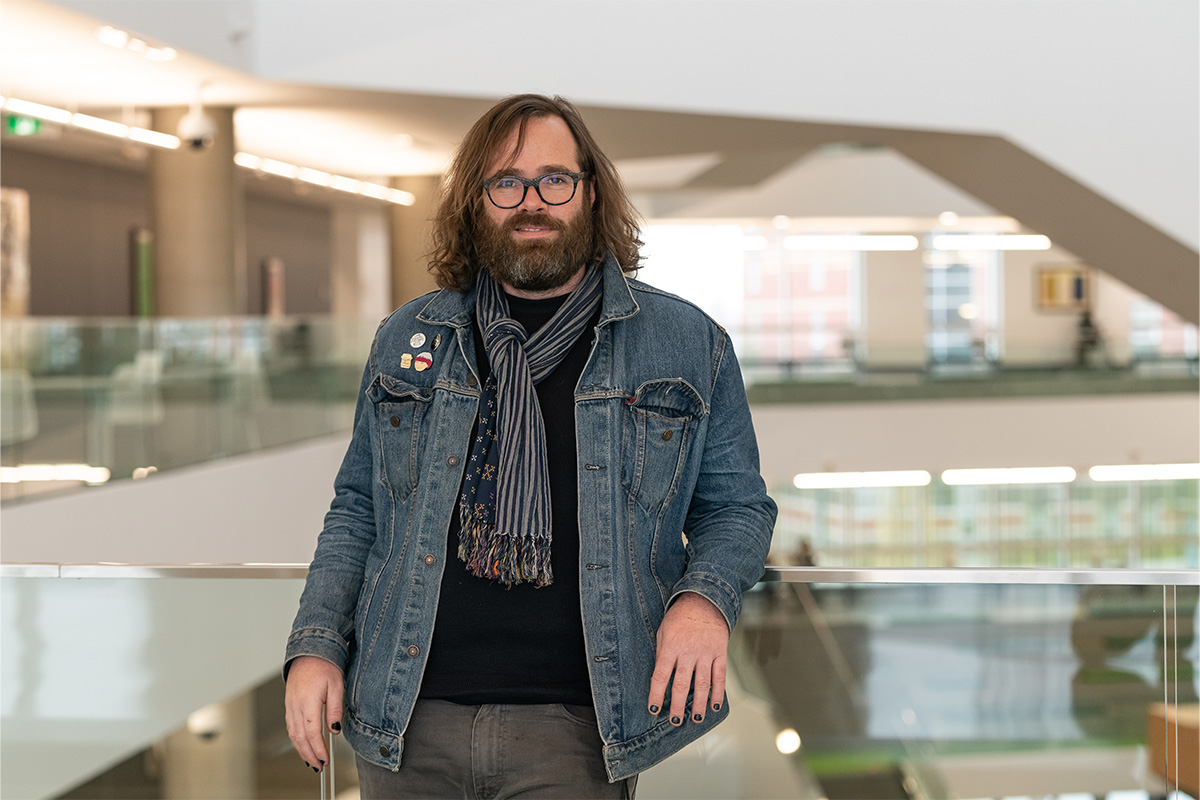 Dr. Michael MacDonald leans against a railing over a staircase in Allard Hall