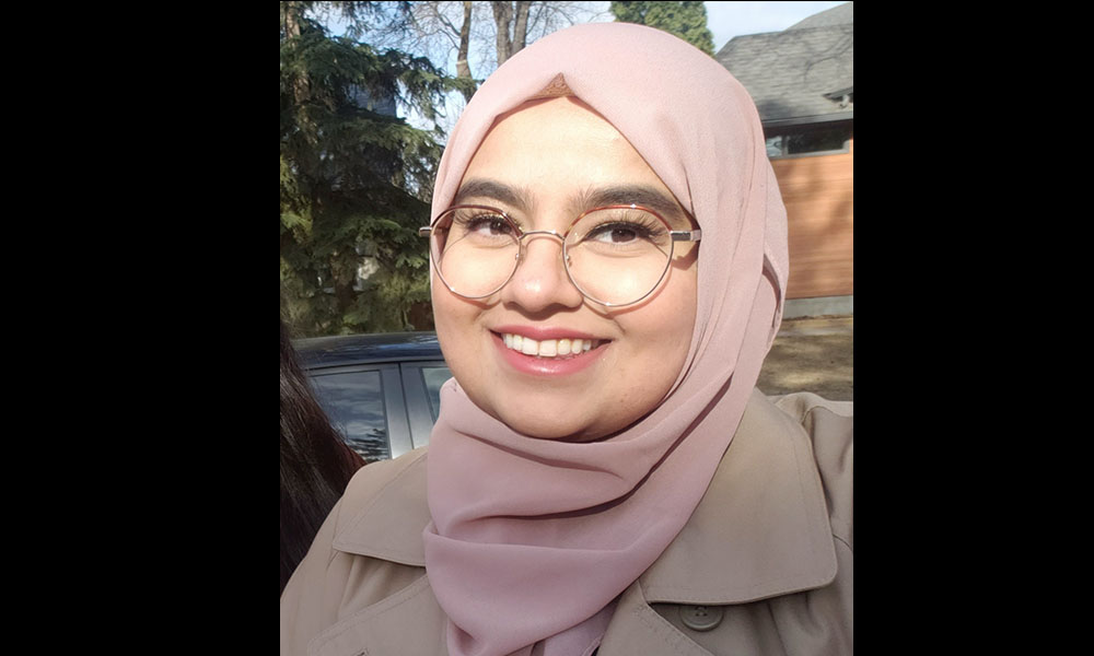 Mominah smiles while standing outdoors