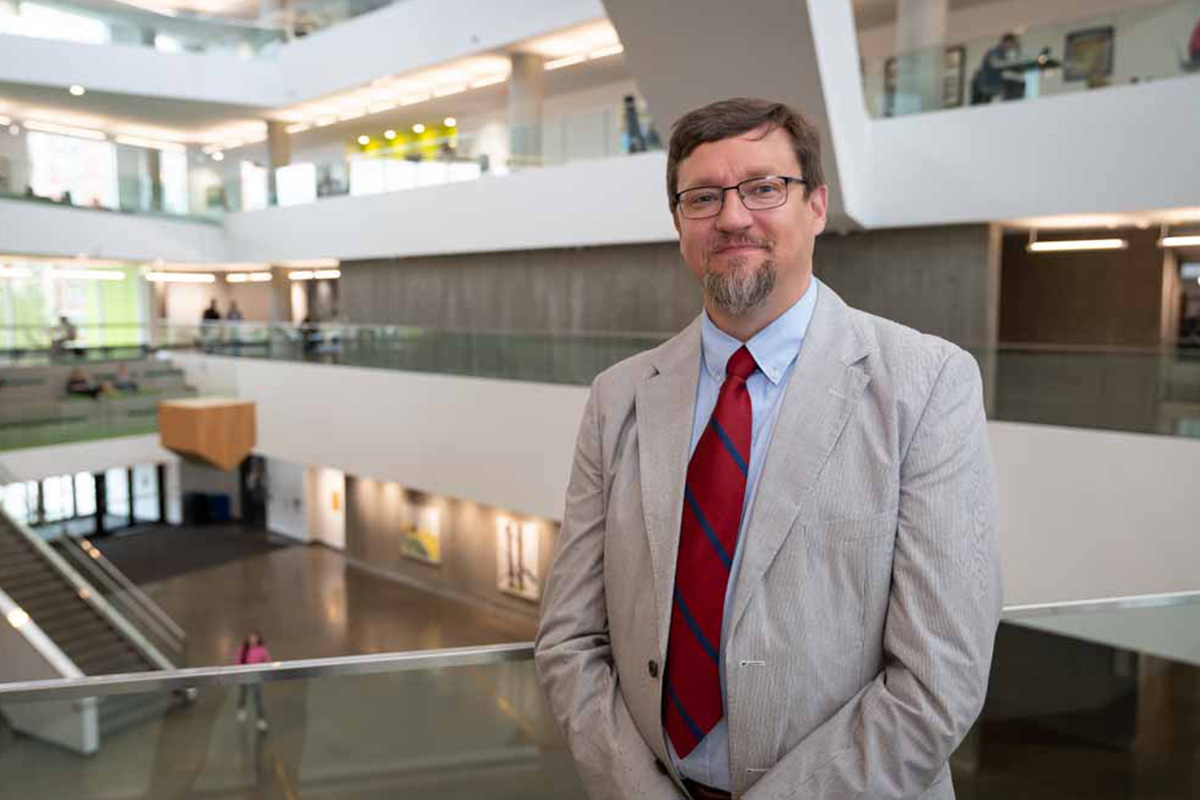 Dr. Benjamin Garstad stands in Allard Hall