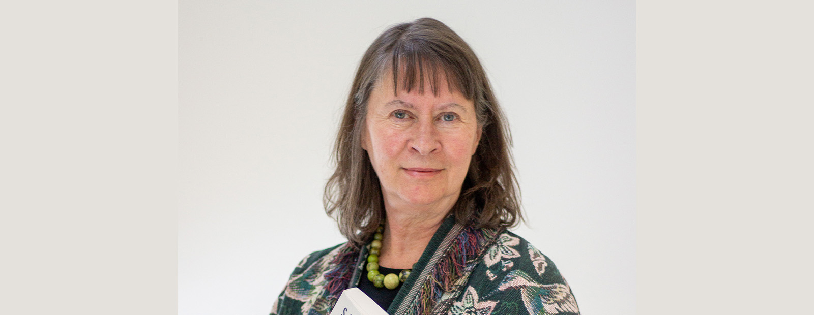 Dr. Sarah Carter holds her book "Imperial Plots" in a posed headshot