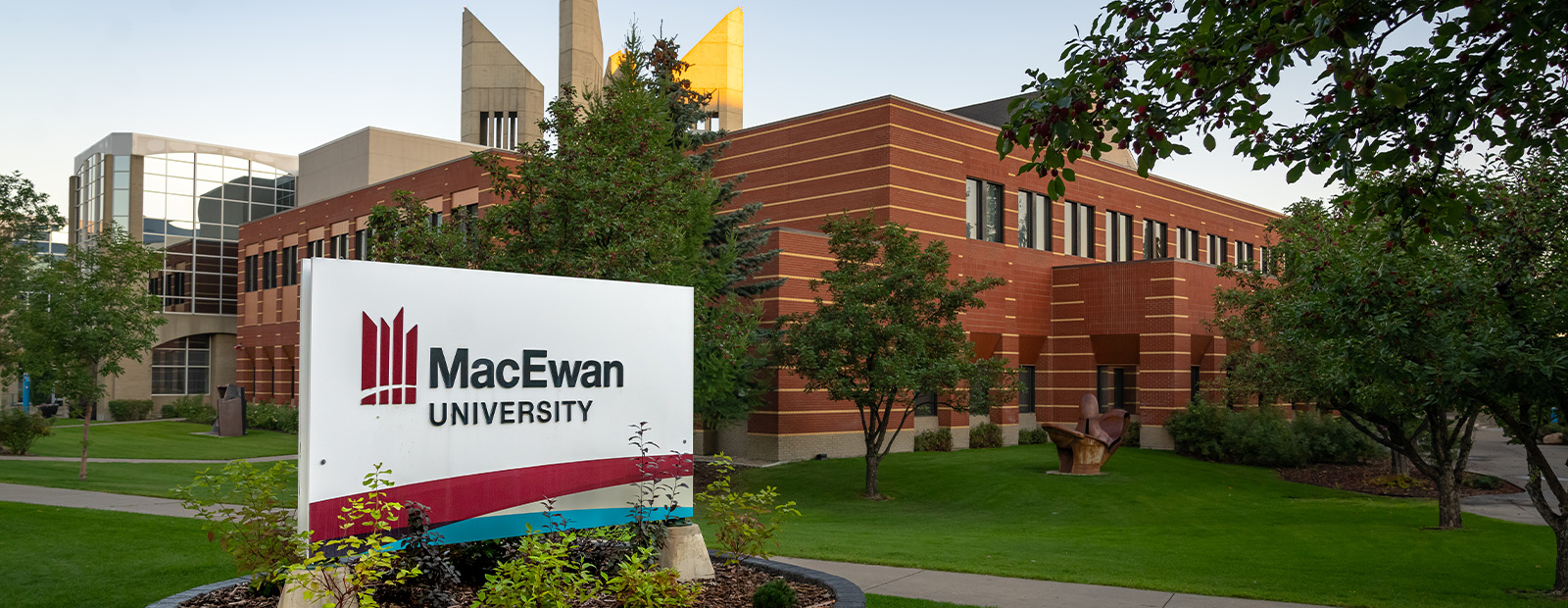 Campus as seen from Building 5, with the MacEwan University sign in the foreground at dawn.