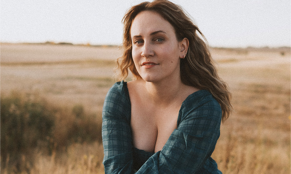 Mallory Chipman sits with a field in the background