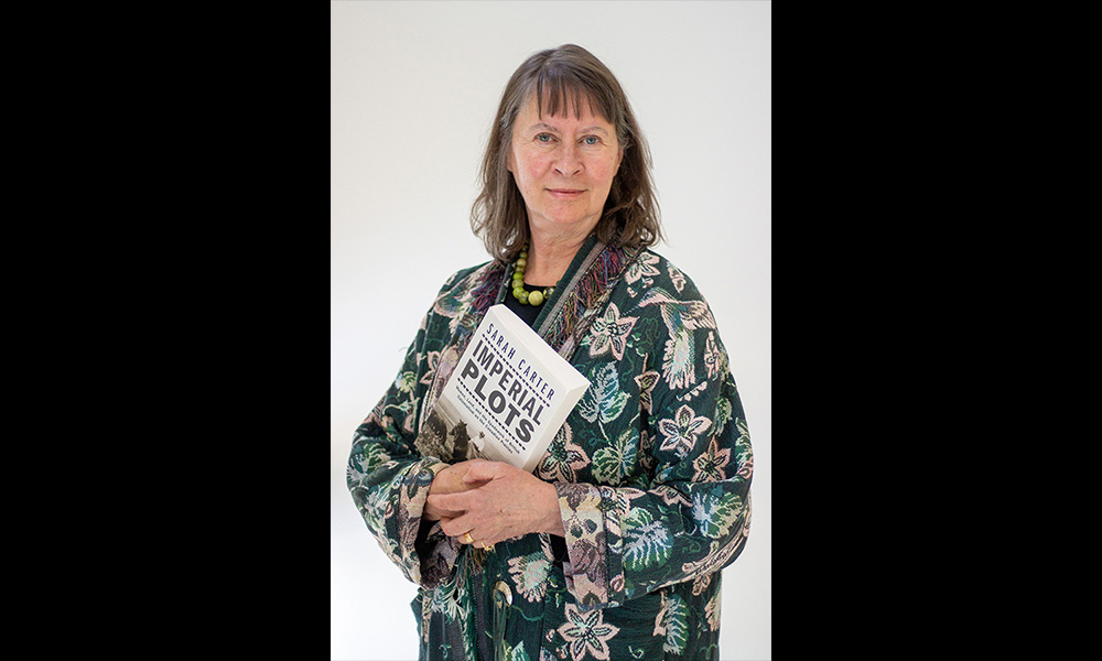 Dr. Sarah Carter holds a copy of her book Imperial Plots