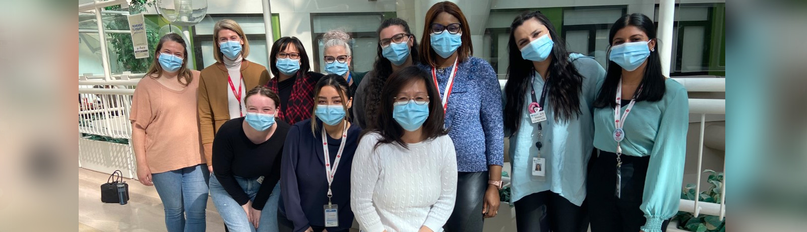 Social work students and faculty from MacEwan and U of C pose together wearing medical masks at the University of Alberta hospital