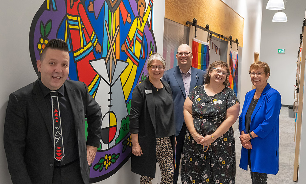 People gather in front of the mural at the Centre for Sexual and Gender Diversity