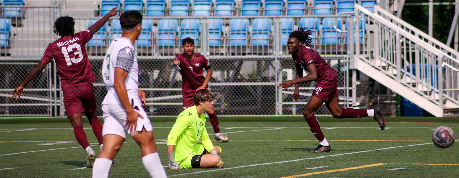 Philip Masri wears his maroon Griffins uniform and runs through a soccer field with teammates.