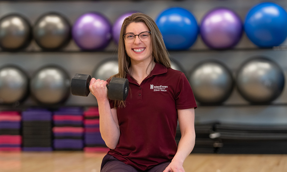 Natasha holds a weight in the gym at MacEwan