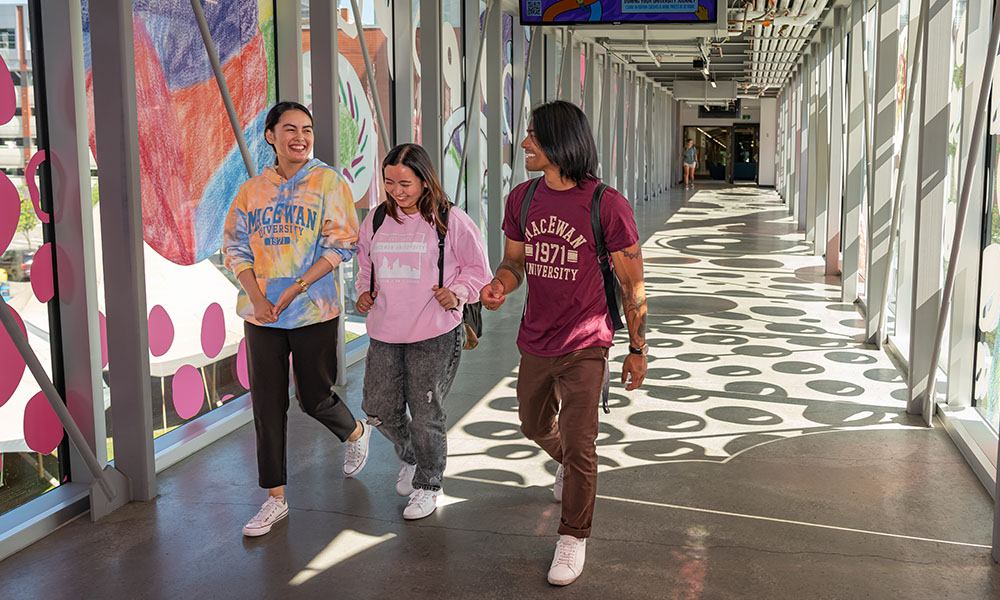 Students walk through the pedway wearing MacEwan shirts