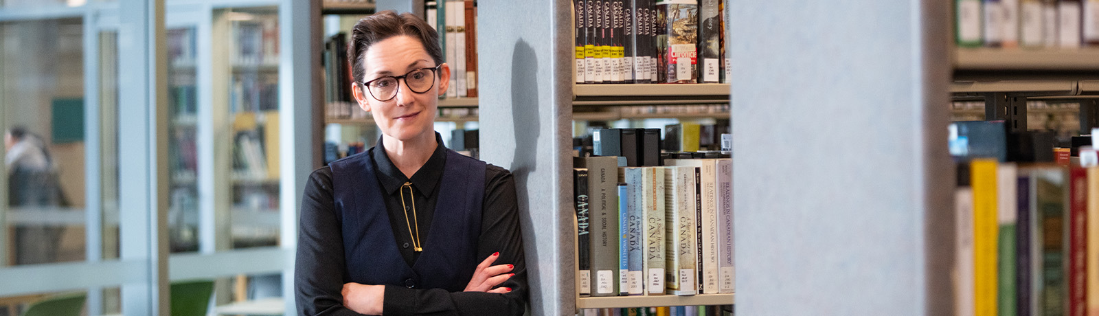 M.L. Martin leaning against a bookshelf