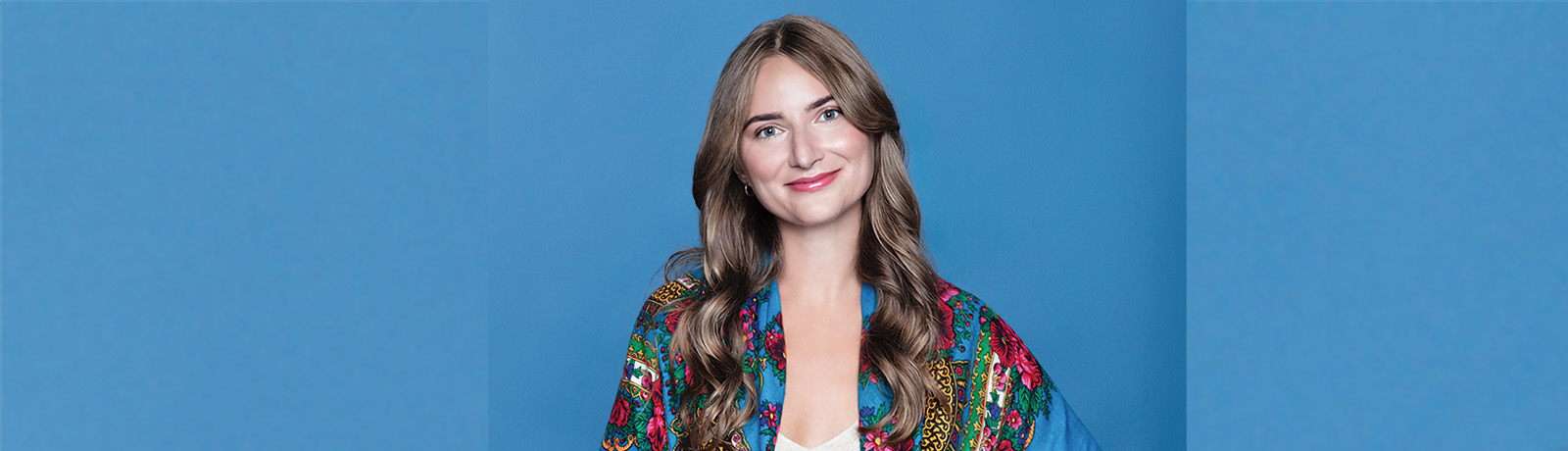 Lianna Makuch poses, smiling, against a blue background.