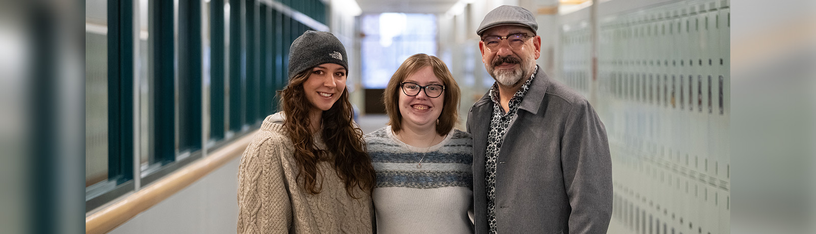 Two students stand with a retired police officer