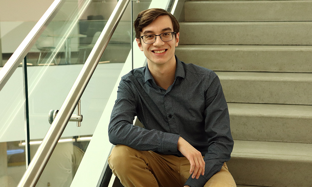 Evan Eng sits on the stairs in Allard Hall