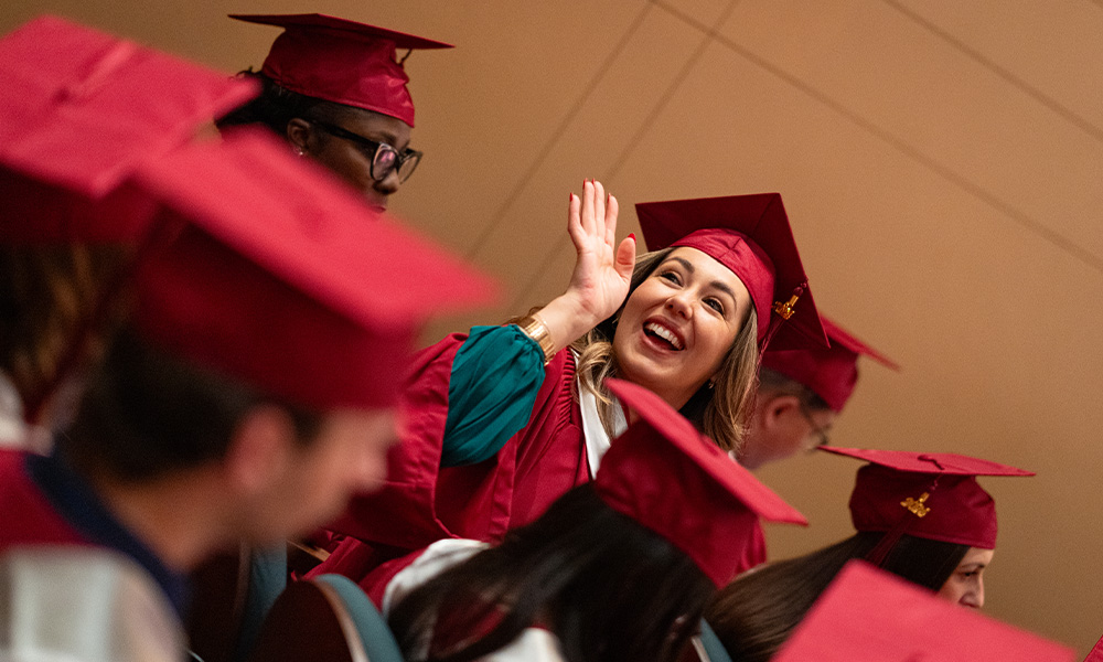 Smiling students in red grad caps