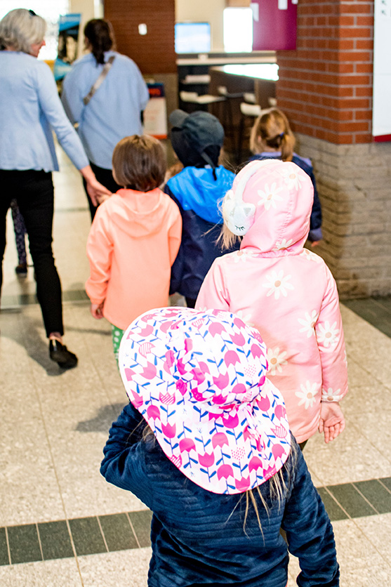 Children walk along a hallway at MacEwan University