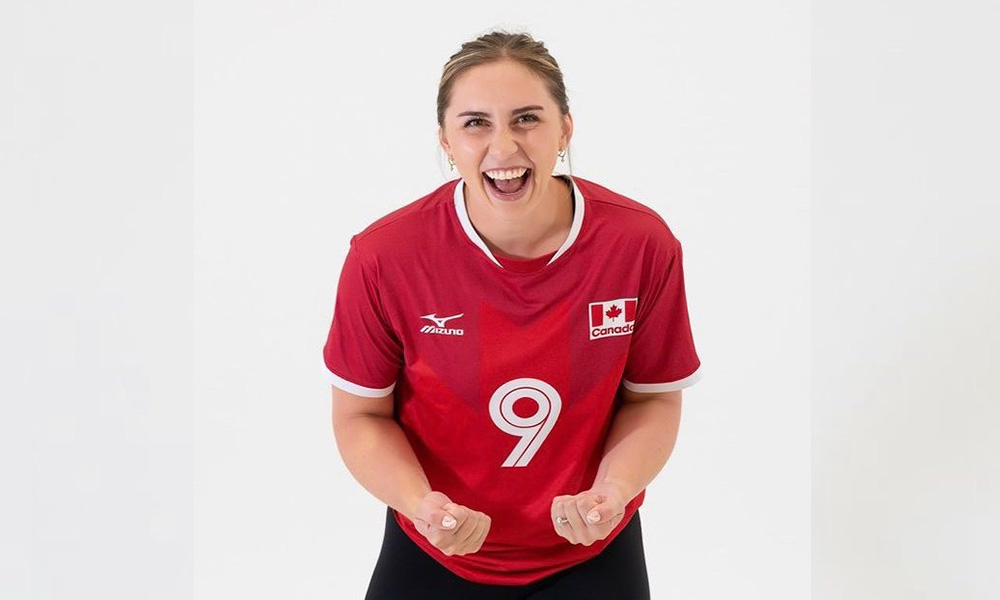 Sarah Melenka clenches her fists in excitement while wearing her Team Canada jersey