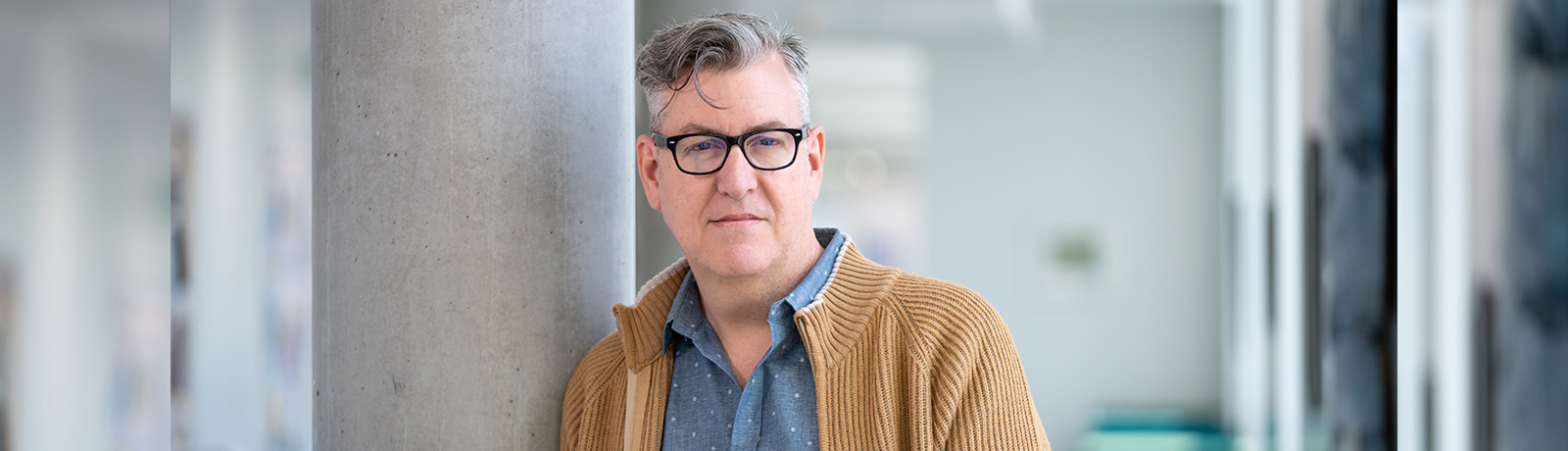 Wayne Williams leans against a concrete pillar in Allard Hall