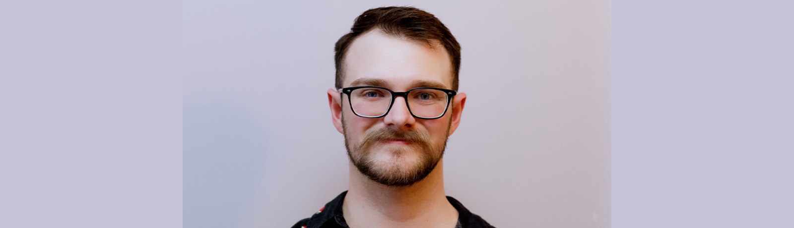 A headshot of Joel Roy against a grey backdrop.