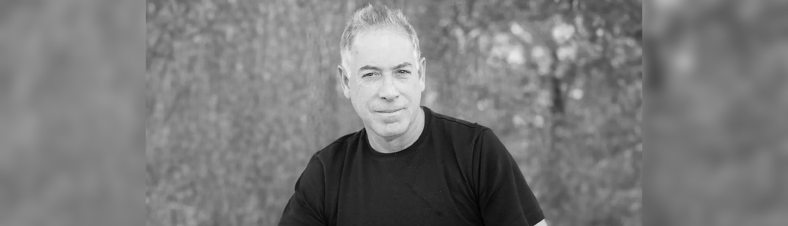 A black and white headshot of Dr. James Canton in front of some plants.