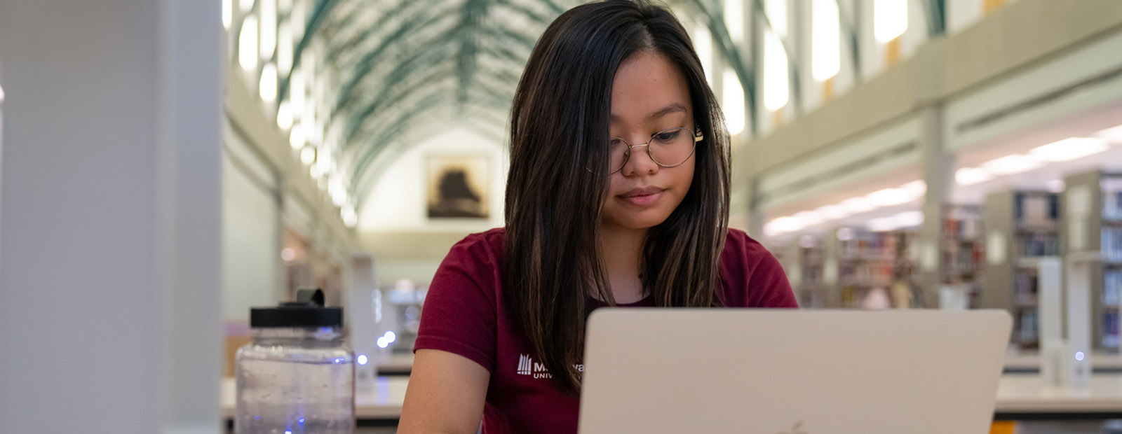 student using laptop in the library