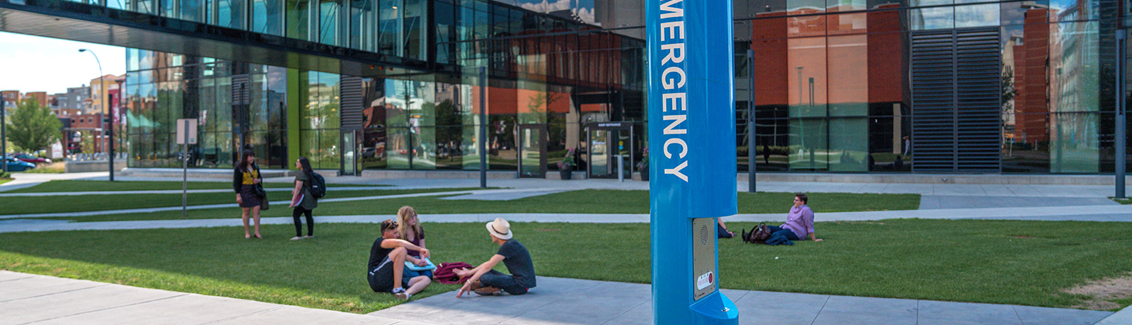 Students talking outside of residence in front of blue emergency phone