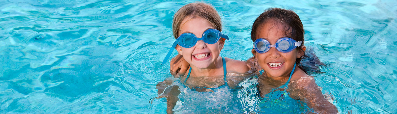 two kids smiling in pool