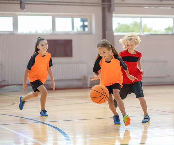 children playing basketball indoors